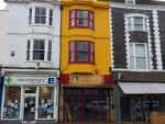 Vista exterior de la fachada amarilla y roja de The Yellow Book en Brighton