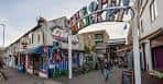 Entrada al mercado abierto de London Road con tiendas y ambiente callejero