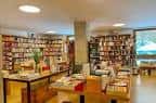 Vista interior de la librería, mostrando estanterías llenas y mesas de exposición.