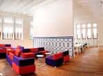 Interior de una sala de descanso o lounge con mobiliario moderno y pared de azulejos