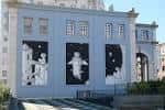 Vista lateral de la fachada con grandes murales temáticos de arte moderno