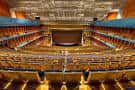 Panorámica del gran auditorio con butacas de tonos naranjas y balcones
