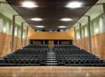 Interior del auditorio o salón de actos con filas de butacas y techo iluminado