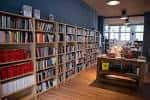 Vista interior de la librería con estanterías llenas de libros y suelo de madera