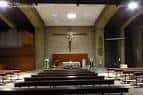 Interior de la iglesia centrado en el altar mayor y el crucifijo, visto desde el pasillo central