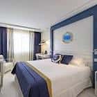 Interior de habitación doble con decoración náutica en tonos azules y blancos