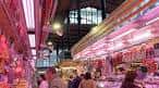 Interior del mercado con puestos de venta y la estructura metálica del techo