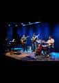 Banda de jazz actuando en el escenario con iluminación azul