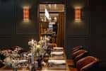 Sala de comedor privado con mesa larga, decoración floral y ambiente íntimo