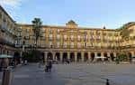 Vista de la Plaza Nueva de Bilbao con terrazas y gente disfrutando del día soleado