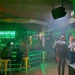 Interior del Dilema Indie Club mostrando la barra iluminada en tonos verdes