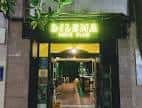 Entrada exterior del Dilema Indie Club con el cartel de neón verde