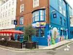 Vista exterior del pub The Actors en Brighton, con fachada azul y zona de terraza