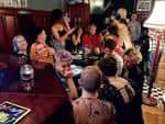 Ambiente interior con un grupo de personas socializando en la zona del bar