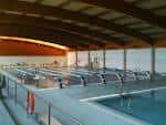 Vista interior de la piscina cubierta con estructura de techo de madera