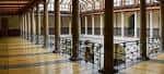 Galería interior del patio central con columnas y barandillas de hierro forjado