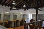 Interior de la sala de estudios con cubículos individuales y techo de vigas de madera a la vista