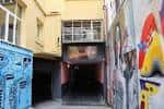 Entrada diurna a la sala Dabadaba a través del túnel rodeado de grafitis