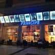Fachada moderna de Cines Príncipe iluminada de noche con el rótulo principal