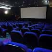 Interior de la sala de cine Trueba con butacas azules y pantalla grande