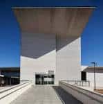 Vista frontal de la moderna fachada de piedra clara del Artium Museoa bajo un cielo azul