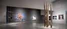 Sala de exposición interior con obras de arte contemporáneo y escultura de madera