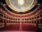 Interior del auditorio principal con butacas rojas y cúpula ornamentada