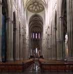 Perspectiva interior de la nave central de la catedral con altas columnas góticas