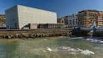 Fachada exterior del Kursaal vista desde la orilla del río Urumea en un día soleado
