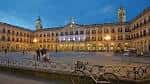 Plaza de España iluminada al anochecer, destacando la fachada del Ayuntamiento