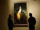 Visitantes observando una obra de arte en una sala de exposición del museo