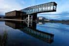 Vista panorámica del edificio Ataria con reflejo dramático en el agua al atardecer