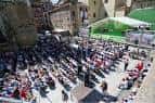 Vista aérea de la Plaza de la Trinidad durante un evento con público sentado y escenario.