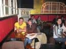 Interior del Pub Ícaro en Vigo con clientes sentados en sofás rojos y mesas