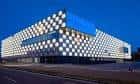 Fachada exterior del Navarra Arena iluminada con patrón de cuadros por la noche.