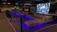Zona de descanso de la sala de eventos con iluminación LED azul y pantalla grande