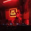 Ambiente de evento nocturno en Ttipia Taberna con DJ y luces rojas
