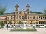 Fachada principal del Ayuntamiento de San Sebastián con la fuente en primer plano bajo el sol