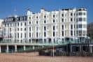 Vista exterior del Queens Hotel Brighton, un edificio blanco clásico frente al mar