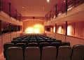 Interior del auditorio principal del Teatro Casino de Trubia con butacas y escenario iluminado