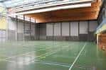 Interior de la pista polideportiva cubierta con estructura de techo de madera