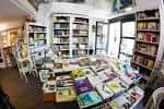 Interior de la librería-café con estanterías llenas de libros y expositores centrales