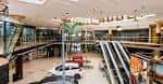 Interior del atrio principal del centro comercial con escaleras mecánicas y múltiples niveles