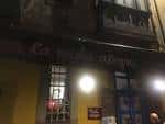 Fachada exterior del local con el rótulo 'La vida alegre' iluminado por la noche