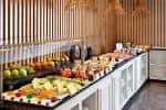 Buffet de catering con variedad de quesos y frutas en el área de desayuno