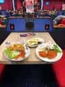 Platos de comida servidos en una mesa dentro del salón de Buzz Bingo Brighton