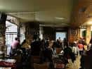 Interior de la taberna durante un evento o reunión con proyector y público
