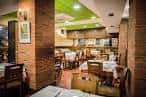 Interior del comedor de la sidrería con mesas puestas y decoración rústica