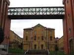 Fachada principal del edificio central del Campus de El Milán, enmarcada por los edificios laterales y el puente metálico superior