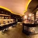 Vista panorámica del salón principal del Pub Lust con asientos corridos y luces de ambiente cálidas
